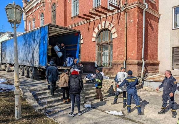 ONU envia ajuda humanitária para a Ucrânia. Imagem mostra um caminhão sendo descarregado em Sumy. Os suprimentos humanitários, que incluíam suprimentos médicos, água engarrafada e alimentos. Também foram enviados equipamentos para reparar sistemas de água
