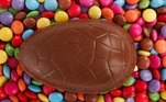 Ovos de Páscoa de chocolate rodeado por confeitos coloridos. Pixabay 