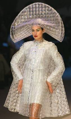 Mais uma das criações apresentadas em 1997, na coleção outono-inverno: capa de chuva de plástico, com efeito de lantejoulas, sobre um vestido de seda pérola e lurex 