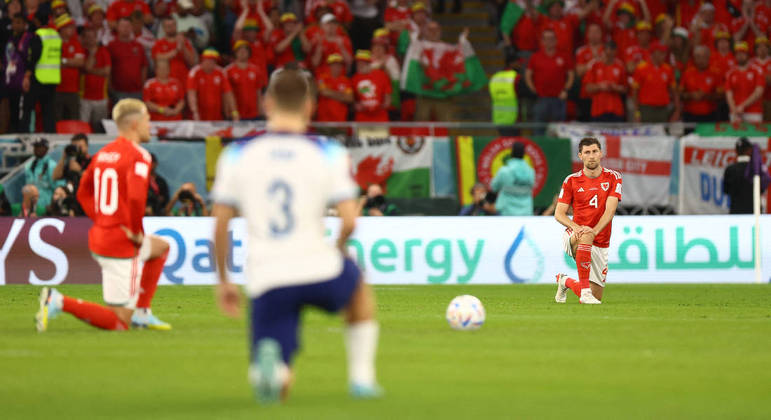 Jogadores de País de Gales e Inglaterra se ajoelham antes de partida decisiva na Copa