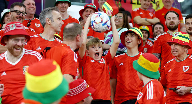 Garotinho pega a bola na arquibancada um pouco antes da partida entre País de Gales e Inglaterra