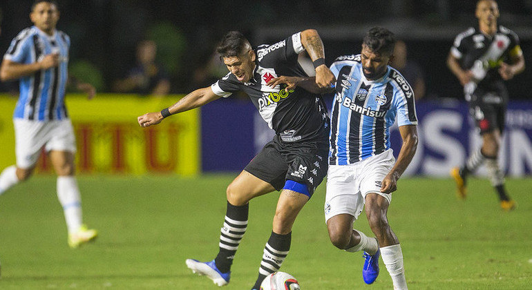 Carlos Palacios em disputa no meio-campo com o volante Thiago Santos, do Grêmio