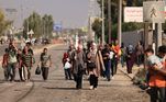 Palestinos que fogem da Cidade de Gaza em direção às áreas sul caminham por uma estrada em 7 de novembro de 2023, em meio aos combates em andamento entre Israel e o grupo terrorista Hamas