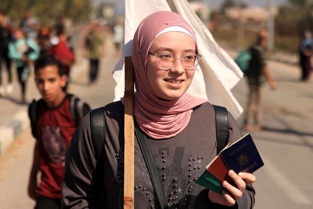 Uma mulher carrega um passaporte ucraniano ao lado de outras pessoas com uma bandeira branca, enquanto palestinos que fogem da Cidade de Gaza em direção às áreas sul caminham por uma estrada. Milhares de civis, tanto palestinos quanto israelenses, morreram desde 7 de outubro de 2023, após terroristas do Hamas palestino baseados na Faixa de Gaza entrarem no sul de Israel em um ataque sem precedentes, desencadeando uma guerra declarada por Israel contra o Hamas com bombardeios retaliatórios em Gaza