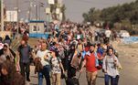 Palestinos que fogem da Cidade de Gaza e outras partes do norte de Gaza em direção às áreas sul caminham por uma rodovia, em meio aos combates em andamento entre Israel e o grupo terrorista palestino Hamas. Milhares de palestinos fugiram a pé em 8 de novembro, em uma onda para longe dos combates e intensos bombardeios em Gaza, enquanto Israel disse que estava apertando o 'cerco' em torno do Hamas. As pessoas caminhavam para o sul da Cidade de Gaza, muitas com nada além das roupas que vestiam, enquanto os combates continuavam mais de um mês após os ataques do Hamas que mataram 1.400 em Israel, provocando a guerra mais mortal de Gaza.