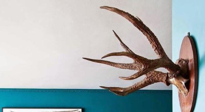 Parede azul com sofá cinza e tapete felpudo