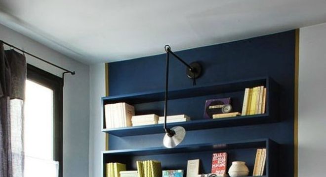 Parede azul em escritório com prateleiras e livros