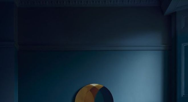 Parede azul escuro com sofá no mesmo tom