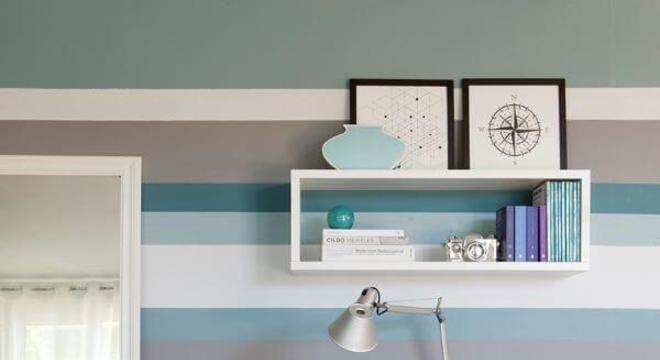 Parede azul listrada em tons neutros e poltrona confortável