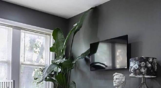 parede cinza para casa com puff redondo rosa e buffet de madeira 