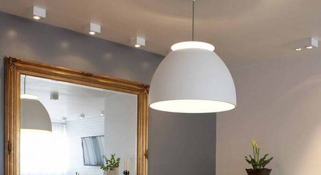 parede cinza para sala de jantar com espelho grande e mesa quadrada