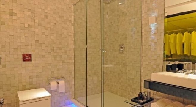 Parede de banheiro revestida com pedra São Tomé