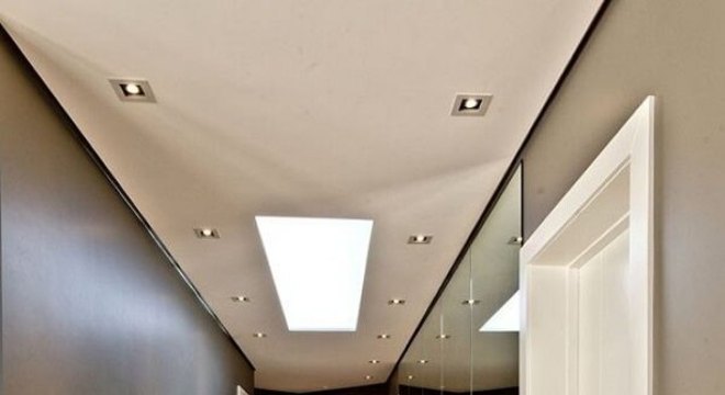 Parede espelhada e piso laminado para o corredor dessa residência