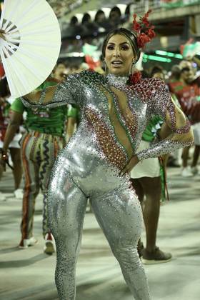 A cantora Pepita com um leque, um adereço na cabeça e um collant prateado com detalhes em vermelho e verde