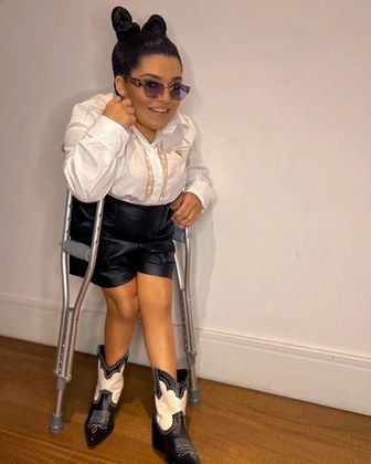 Pequena Lô também estava toda trabalhada no preto e no branco. Ela combinou uma camisa social com shorts e botas futuristas