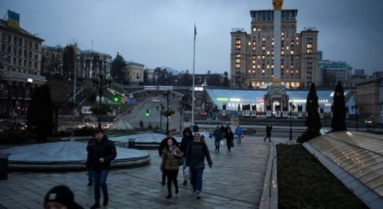Pessoas caminham no centro de Kiev, na Ucrânia, em frente ao Monumento da Independência