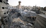 Pessoas estão entre os escombros de uma mesquita destruída durante ataques aéreos israelenses, na cidade de Gaza, em 9 de outubro de 2023.