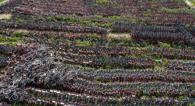 Cemitérios de bicicleta como este na China evidenciaram o problema do crescimento desordenado dos serviços de compartilhamento