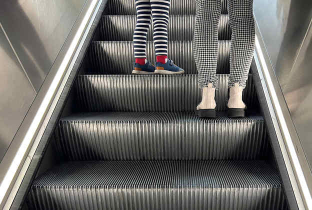 Aquele típico cotidiano despercebido: passageiras usam a escada rolante de uma estação de metrô londrina
