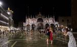 Às vezes Veneza inunda mais do que deveria, como mostra essa imagem, com turistas caminhando em uma praça atingida por uma enchente inesperada