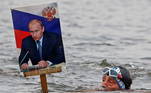 Um competidor do clube de natação de inverno local nada no rio Ob durante as festividades do 69º aniversário do presidente russo Vladimir Putin