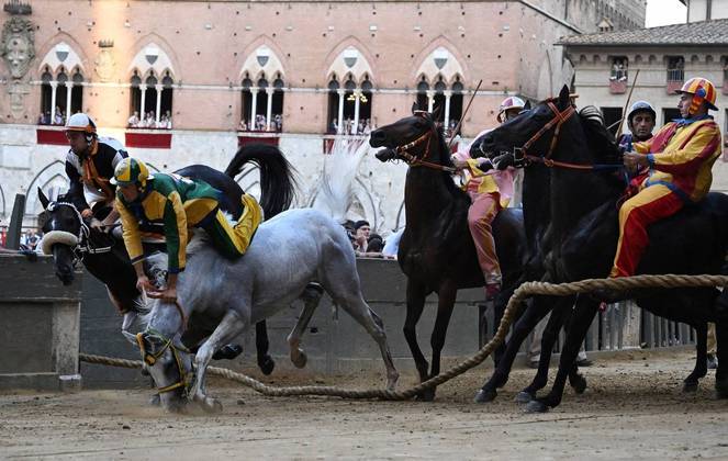 Uma tradicional corrida de cavalos, a todo vapor na cidade de Siena, na Itália