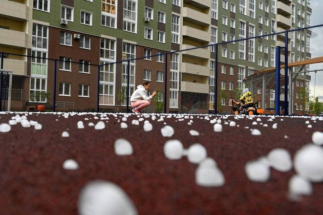 Uma mulher tira fotos de uma criança em um campo esportivo coberto de granizo, após uma tempestade na cidade siberiana de Omsk, RússiaCONTINUE POR AQUI: Somente pessoas com visão aguçada conseguem achar esses números escondidos. Você é capaz?