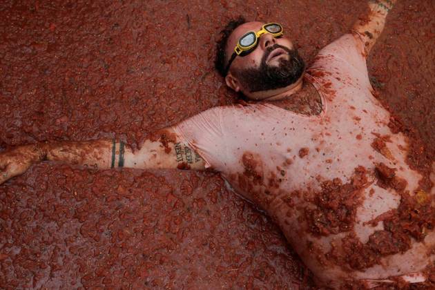 O mundo gira e o planeta continua maluco! E sujo, como é possível ver na imagem acima, um registro do momento de descanso de um participante da tradicional festa La Tomatina, em Bunol, na Espanha