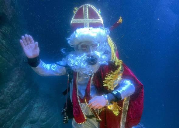 Um mergulhador vestido de Papai Noel posa dentro de um aquário no aquário Sea Life em Munique, na Alemanha