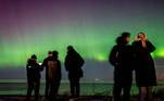 O mundo gira e o planeta continua maluco! E bonito... como mostra a imagem acima, em que pessoas observam o espetáculo da aurora boreal da praia de Hornbaek, na Dinamarca
