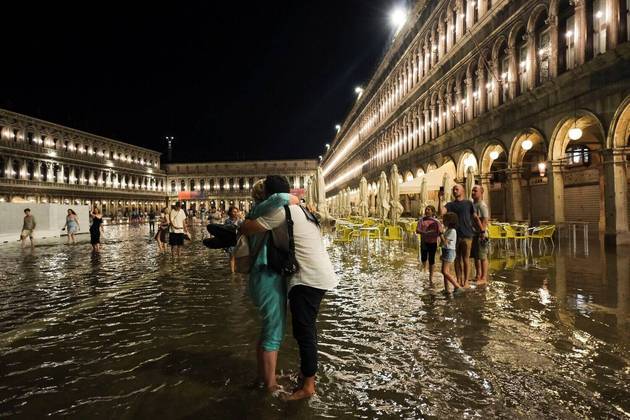 Em Veneza, na Itália, a água subiu e inundou a Praça de São Marcos. Restou aos turistas passarem pela região alagada mesmo