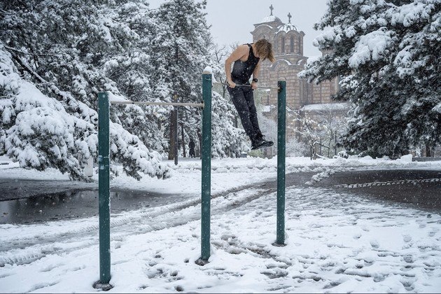 Frio? Que frio?! Homem se exercita em um equipamento de ginástica ao ar livre, no Parque Tasmajdan durante uma rara nevasca de primavera, no centro de Belgrado, SérviaVALE SEU CLIQUE: Barbie humana com lábios gigantes está em busca de um novo amor: 'Tenho aparência extravagante'