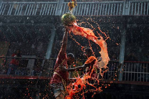 Um participante quebra uma panela de barro que contém coalhada durante um festival hindu, em Mumbai, na Índia