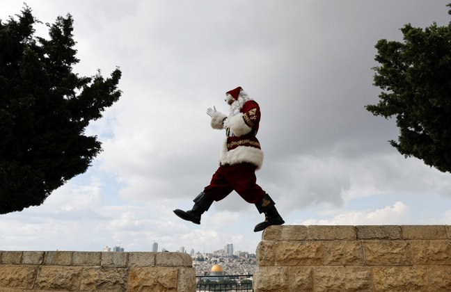 O Natal está logo ali, e o Papai Noel já está no modo inconsequente. No caso, a Papai Noel Issa Kassissieh, que caminha fantasiada durante o Natal no monte das Oliveiras, em Jerusalém (Israel)