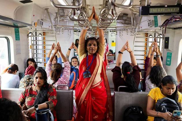 Mulheres praticam ioga em um trem local, por ocasião do Dia Internacional da Mulher, também em Mumbai