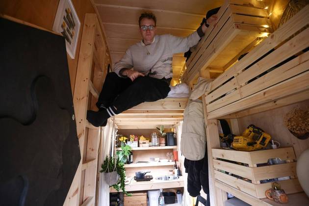 O artista Harrison Marshall posa dentro da caçamba que transformou em casa, onde pretende morar por um ano, em LondresVEJA MAIS: Policiais descobrem mulher trancada em apartamento com o filho desde o início da pandemia