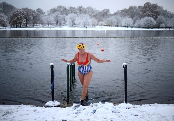 Uma nadadora mergulha os pés no lago Serpentine, enquanto o tempo frio continua no Reino Unido