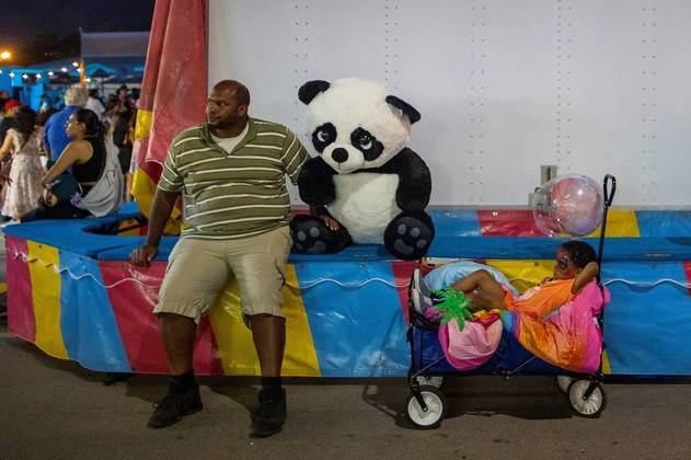 Um homem e uma criança (e um panda!) esperam a reabertura da Exposição Nacional Canadense, após dois anos sem o evento, por um motivo que nem precisamos citar