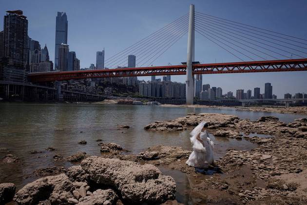 O mundo continua maluco, como é possível ver por esse lindo e estranho registro de uma noiva, que caminha no leito seco do rio Jialing, um afluente do Yangtzé, que se aproxima de níveis negativos recordes e preocupa autoridades da China