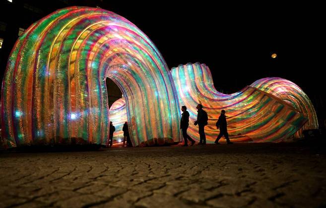 Na abertura do festival de arte River of Light, em Liverpool, visitantes interagem com a instalação Elysian Arcs