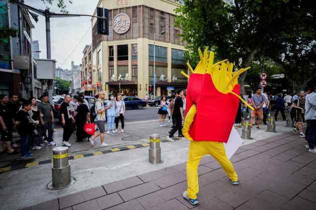 Em uma rua de Xangai, na China, uma pessoa vestida como mascote de batatas fritas diverte o público em frente a um mercadoNão saia daí! Caso único: crocodilo virgem engravida por conta própria, mas bota ovo com natimorto