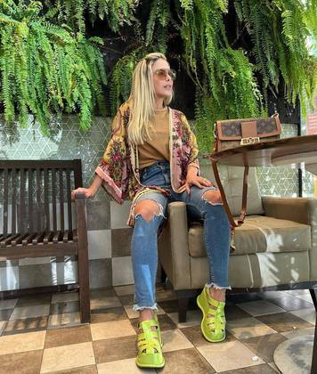 Aqui, a mãe de Zé Felipe dá mais um exemplo de visual moderno e juvenil composto de calça jeans rasgada, camiseta, cardigã florido e sandálias verdes neon