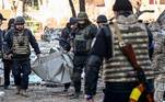 Policiais ucranianos carregam corpo após ataque russo em área residencial de Kiev