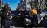 Policiais ucranianos revistam homem suspeito