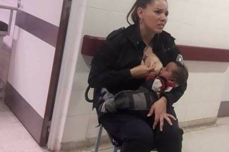 Policial, ainda fardada, amamentando um bebê em hospital