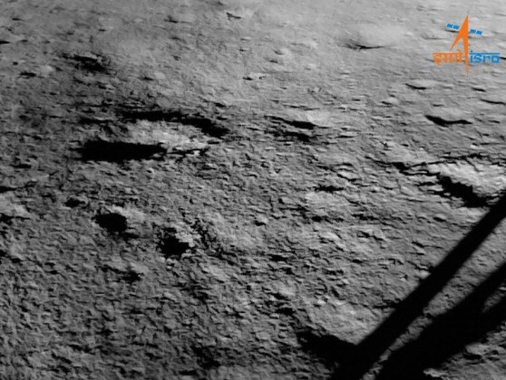 Depois de ter conseguido pousar no escuro e inexplorado polo sul da Lua, o explorador robótico da missão indiana Chandrayaan-3 enviou a primeira imagem do local. A foto da superfície foi tirada logo após o pouso e divulgada pela ISRO (Organização Indiana de Pesquisa Espacial) — a captura mostra uma região sem grandes acidentes geográficos nem crateras