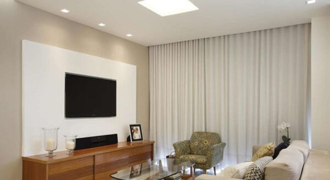 Poltrona para sala de tv com tecido estampado se mistura com o sofá neutro