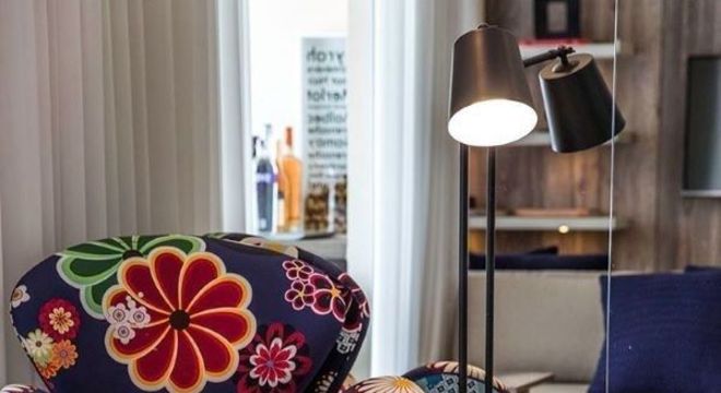 Poltrona tulipa estampada com flores e tons vibrantes para decorar a sala de estar