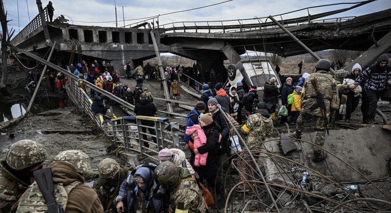 População de Irpin passa pelos escombros de ponte para fugir do avanço das tropas russas
