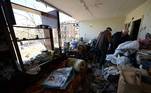 Idoso tenta recuperar seus pertences em apartamento destruído após bombardeio em Kiev